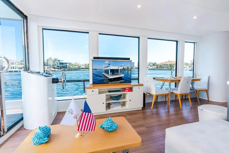  Yacht Photos Pics Modern yacht interior with large windows, elegant furnishings, and a scenic waterfront view.