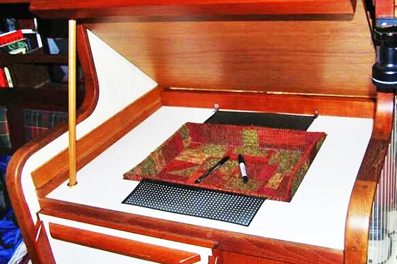 Jolie Brise Yacht Photos Pics Interior of 1985 Sam L. Morse Bristol Channel Cutter 28, featuring a wooden navigation desk.