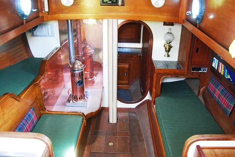Jolie Brise Yacht Photos Pics Interior of a 1985 Sam L. Morse Bristol Channel Cutter 28, featuring cozy wooden furnishings.