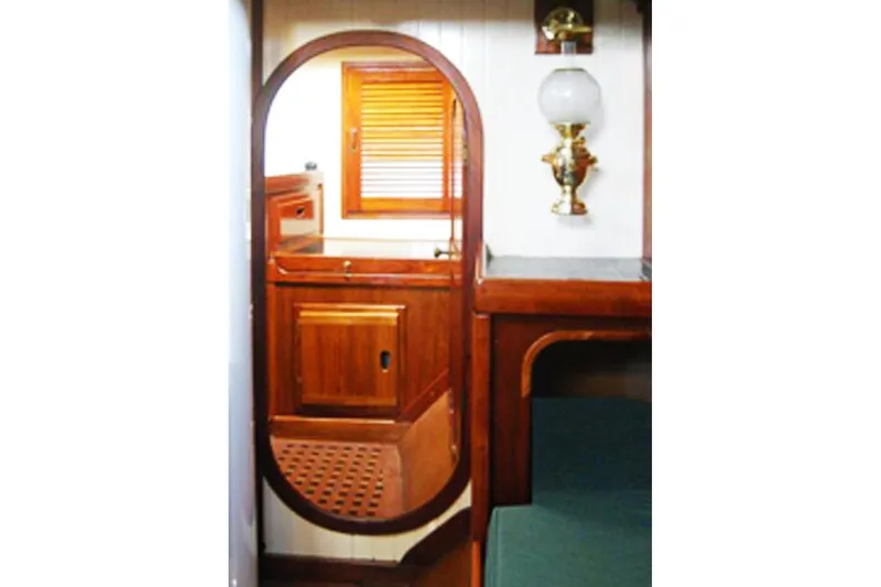 Jolie Brise Yacht Photos Pics Interior of 1985 Sam L. Morse Bristol Channel Cutter 28, featuring wooden cabinetry and nautical decor.