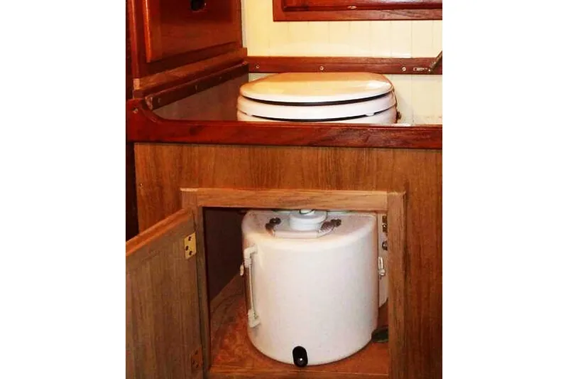 Jolie Brise Yacht Photos Pics 1985 Sam L. Morse Bristol Channel Cutter 28 interior with marine toilet and storage compartment.