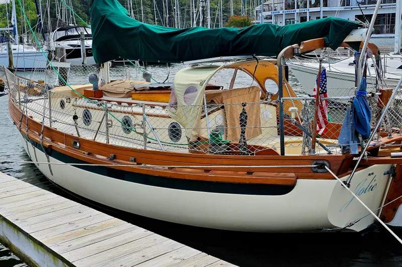 Jolie Brise Yacht Photos Pics 1985 Sam L. Morse Bristol Channel Cutter 28 docked, featuring classic wooden design and green sail cover.