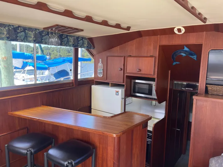 Kylieb Yacht Photos Pics Interior of 1986 Chris-Craft 422 Commander yacht with wooden cabinetry and bar area.