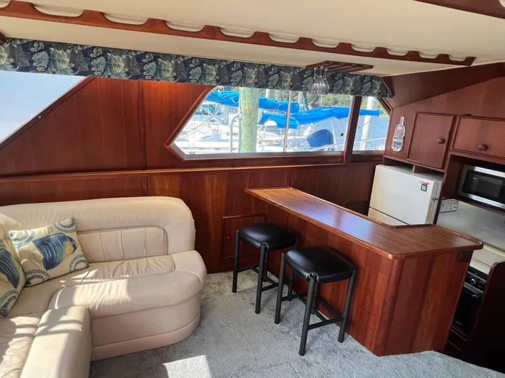 Kylieb Yacht Photos Pics Interior of 1986 Chris-Craft 422 Commander yacht with cozy seating and kitchenette.