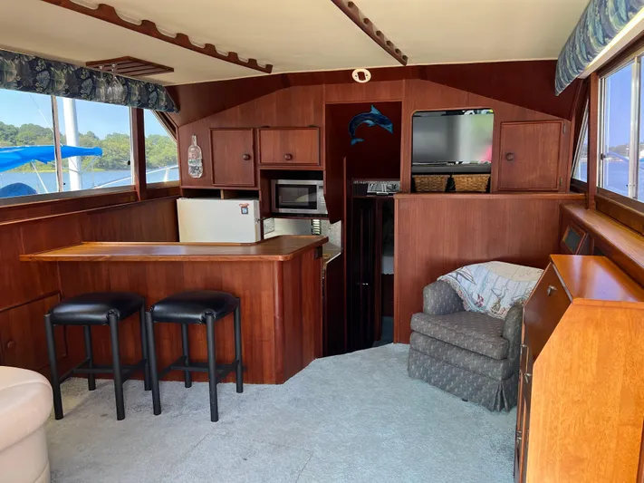 Kylieb Yacht Photos Pics Interior of 1986 Chris-Craft 422 Commander with bar, seating, and wood cabinetry.