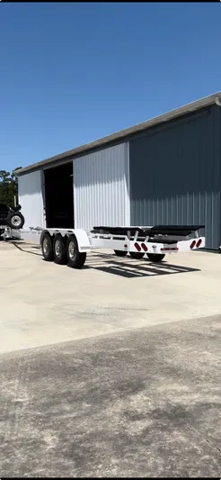 Rage N Thunder Yacht Photos Pics 2002 Black Thunder 460 EC boat trailer parked outside a large metal building.