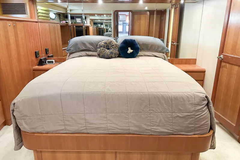 "mi Alma" Yacht Photos Pics Luxurious 2004 West Bay Sonship yacht bedroom with elegant wood finishes and plush bedding.