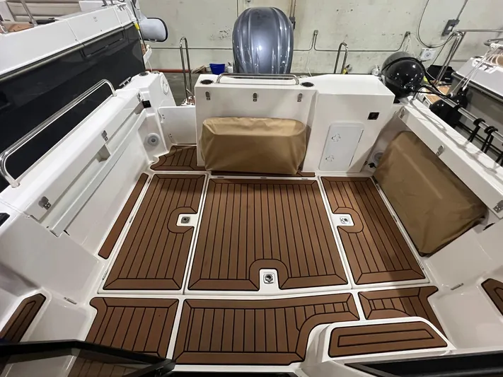 Regulus Yacht Photos Pics 2023 Ranger Tugs R-25 boat deck with wood-style flooring and storage compartments.