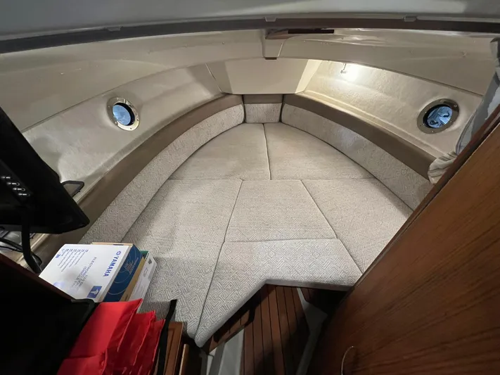 Regulus Yacht Photos Pics 2023 Ranger Tugs R-25 cabin interior with cozy seating and porthole windows.