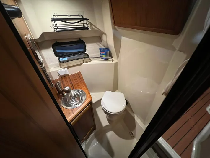 Regulus Yacht Photos Pics 2023 Ranger Tugs R-25 boat bathroom with sink, toilet, and storage shelves.