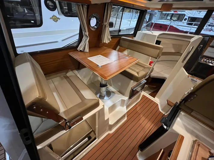 Regulus Yacht Photos Pics 2023 Ranger Tugs R-25 interior with wood accents and seating area.