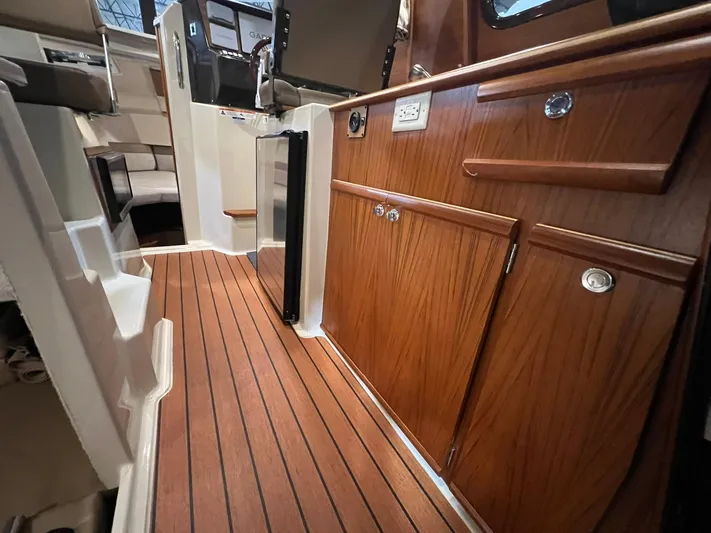Regulus Yacht Photos Pics 2023 Ranger Tugs R-25 interior with wood cabinetry and flooring, showcasing modern design.