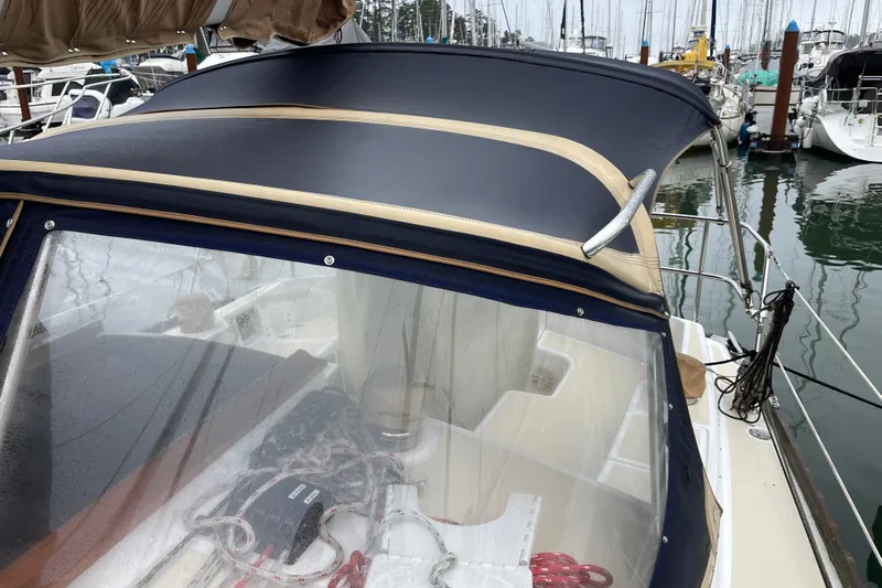 Rhyme Yacht Photos Pics 2007 Tartan 3400 sailboat with navy canvas cover docked at marina.