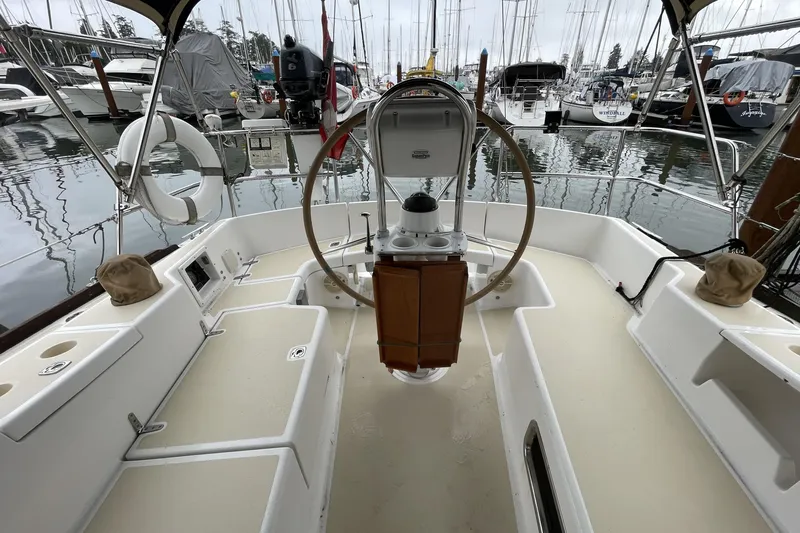 Rhyme Yacht Photos Pics Cockpit of 2007 Tartan 3400 sailboat docked in marina, featuring steering wheel and seating.