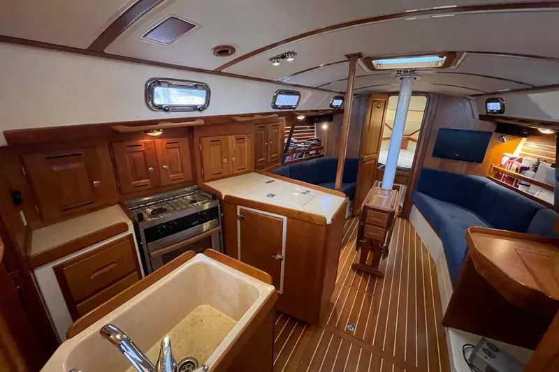 Rhyme Yacht Photos Pics Luxurious 2007 Tartan 3400 yacht interior with wood finish, kitchen, and seating area.