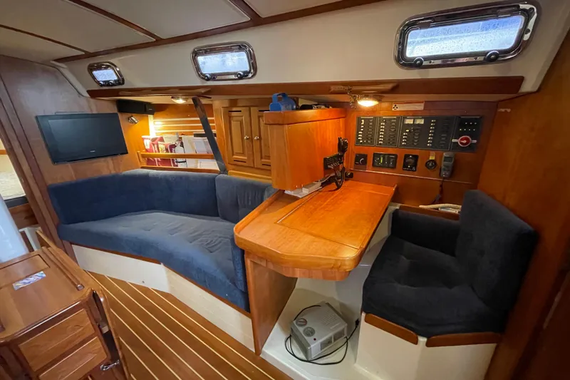 Rhyme Yacht Photos Pics Interior of 2007 Tartan 3400 sailboat with cozy seating and navigation station.