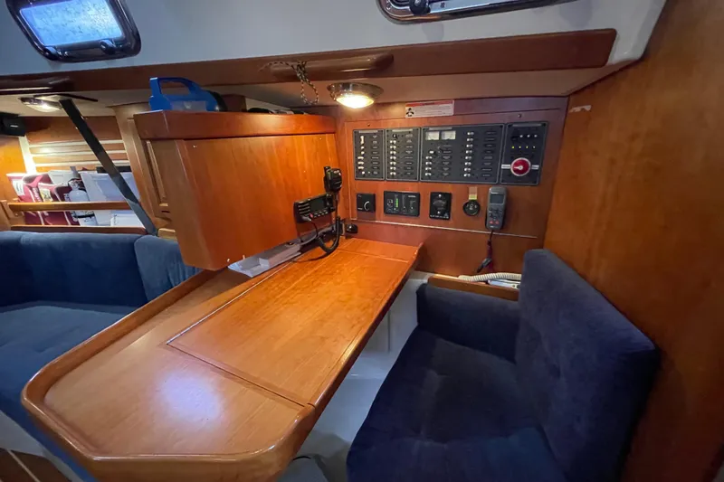 Rhyme Yacht Photos Pics Navigation station inside 2007 Tartan 3400 sailboat with control panels and seating.