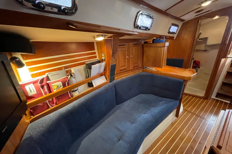 Rhyme Yacht Photos Pics Interior of 2007 Tartan 3400 sailboat with blue seating and wooden cabinetry.