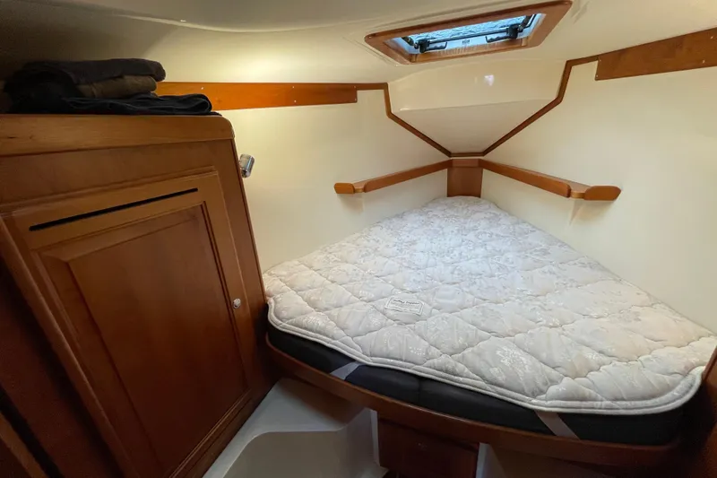 Rhyme Yacht Photos Pics Cozy cabin interior of 2007 Tartan 3400 sailboat with wooden accents and mattress.
