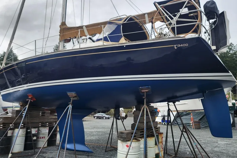 Rhyme Yacht Photos Pics Sailboat Tartan 3400, 2007 model, on dry dock with blue hull and white stripes.