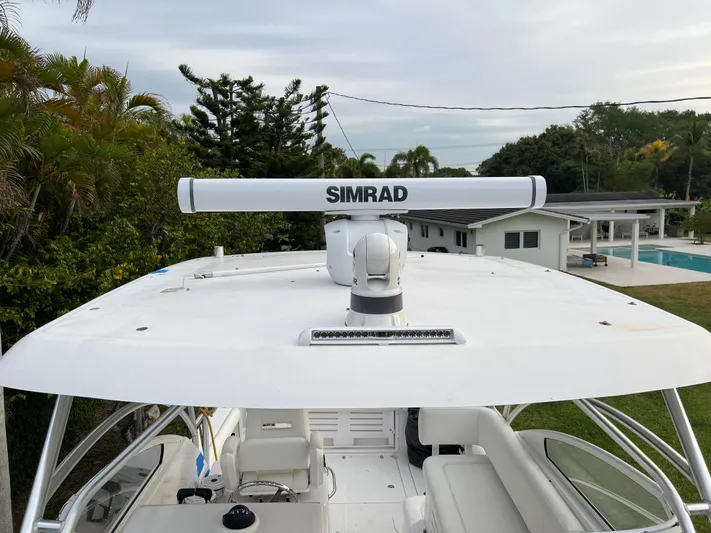 Sea Stress Yacht Photos Pics 2008 Pro-Line 32 Express boat with Simrad radar, docked near a modern house and pool.