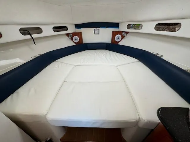 Sea Stress Yacht Photos Pics 2008 Pro-Line 32 Express cabin interior with white and blue seating, speakers, and storage compartments.
