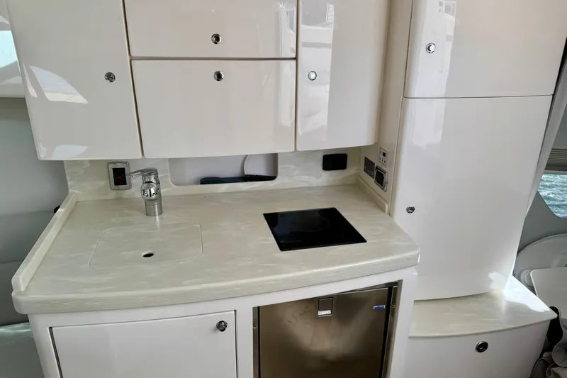  Yacht Photos Pics Modern kitchen area in a 2019 Intrepid 407 Cuddy boat, featuring sleek cabinetry and appliances.