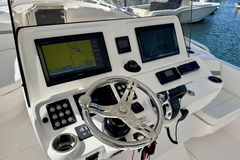  Yacht Photos Pics Control panel of 2019 Intrepid 407 Cuddy boat with navigation screens and steering wheel.