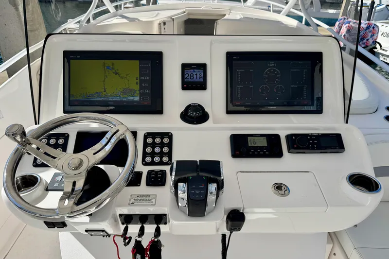  Yacht Photos Pics Control panel of 2019 Intrepid 407 Cuddy boat with navigation screens and steering wheel.