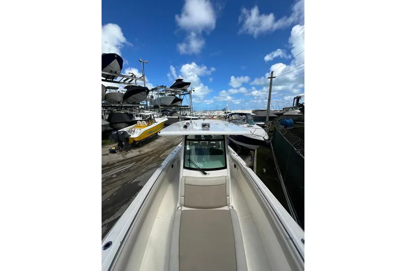  Yacht Photos Pics 2022 Boston Whaler 330 Outrage boat docked under a clear blue sky.