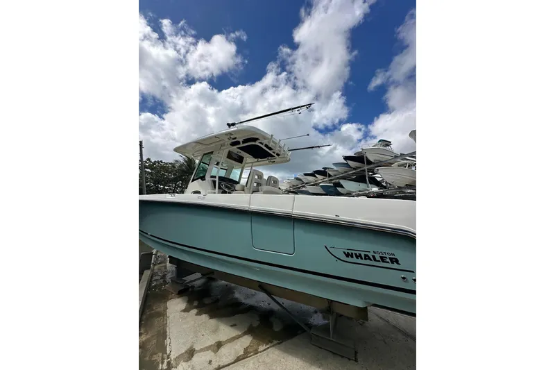  Yacht Photos Pics 2022 Boston Whaler 330 Outrage boat under a partly cloudy sky.