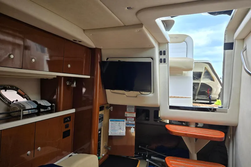 No Woke Zone Yacht Photos Pics 2008 Sea Ray 310 Sundancer cabin interior with TV and wooden cabinetry.