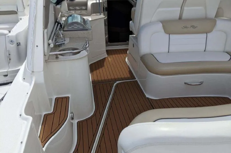 No Woke Zone Yacht Photos Pics 2008 Sea Ray 310 Sundancer interior with seating and kitchenette, featuring wood-style flooring.