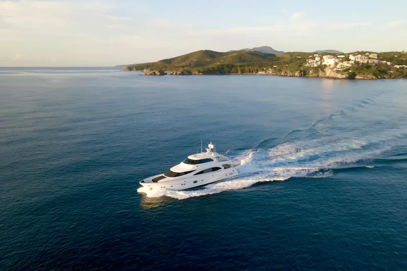 Tortuga Yacht Photos Pics Luxurious 2011 Horizon E88 yacht cruising near scenic coastline at sunset.