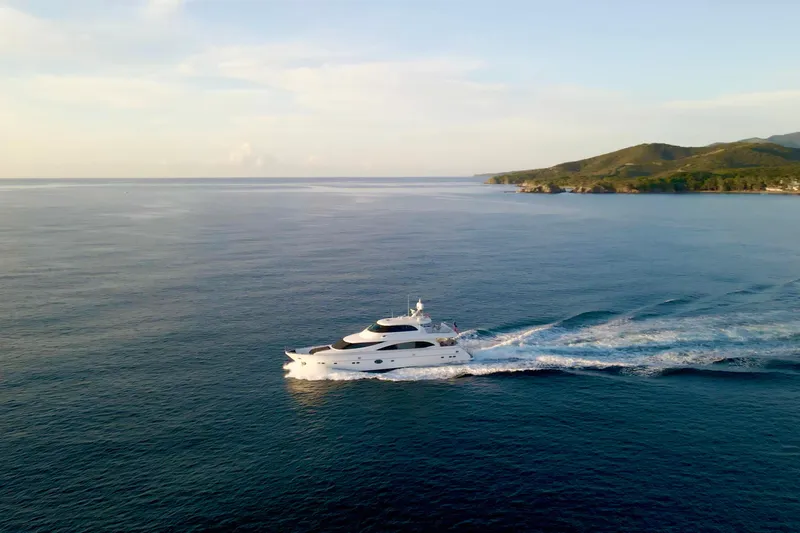 Tortuga Yacht Photos Pics Luxurious 2011 Horizon E88 yacht cruising on serene ocean near lush coastline.