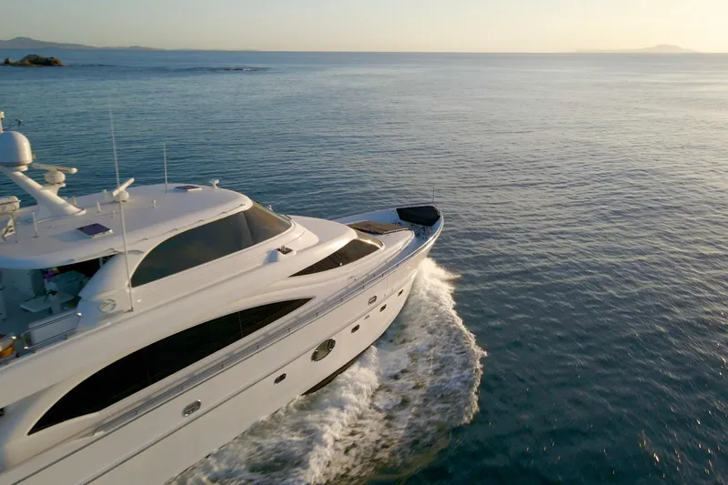 Tortuga Yacht Photos Pics Luxurious 2011 Horizon E88 yacht cruising on calm ocean waters at sunset.