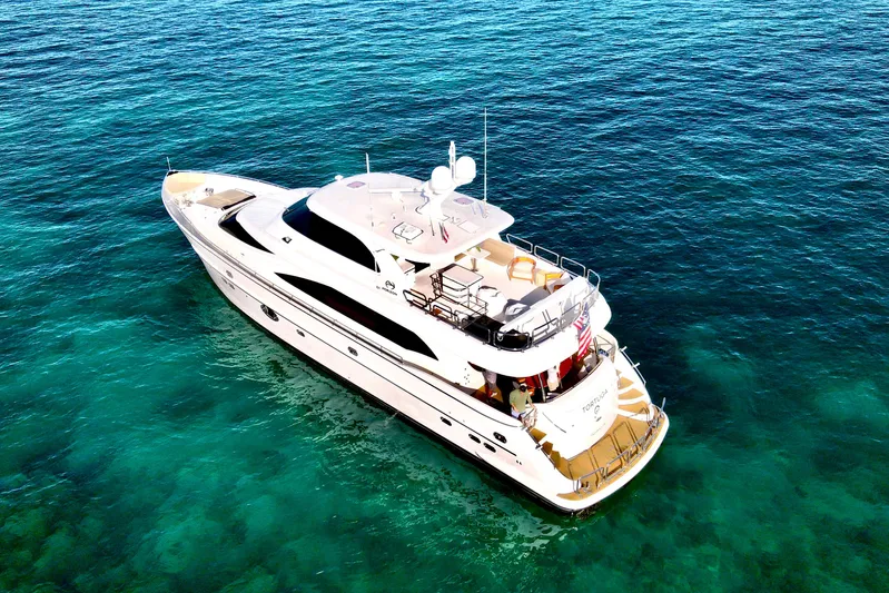 Tortuga Yacht Photos Pics Luxurious 2011 Horizon E88 yacht cruising on clear blue ocean waters.