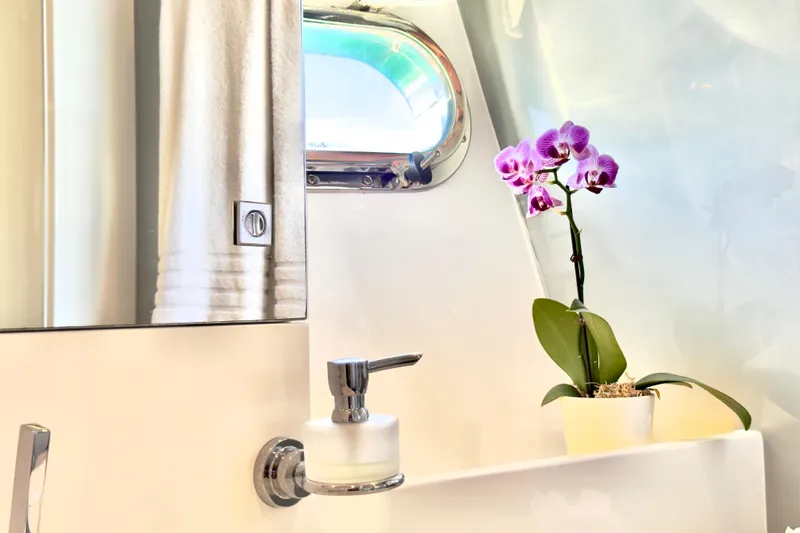 Tortuga Yacht Photos Pics Bathroom interior of 2011 Horizon E88 yacht with orchid and porthole window.