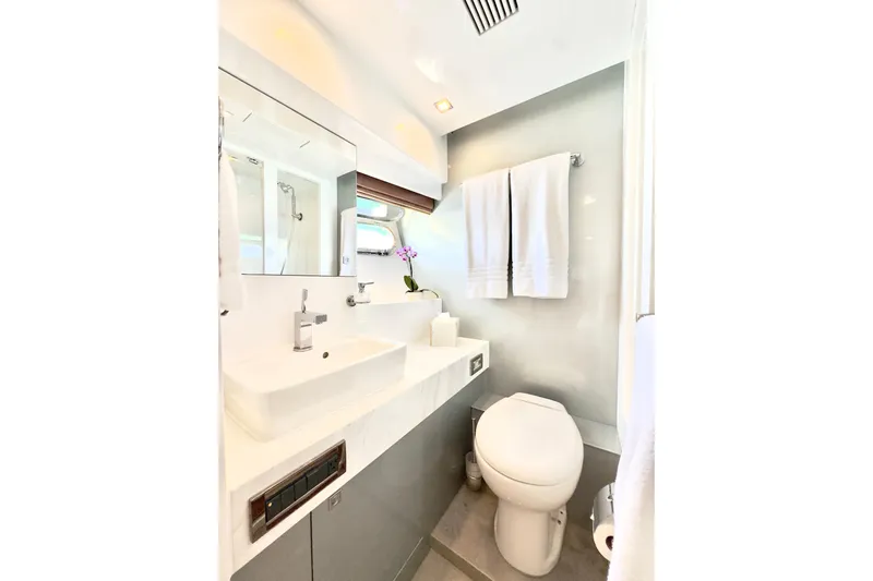 Tortuga Yacht Photos Pics Luxurious yacht bathroom with modern fixtures, white towels, and orchid, Horizon E88, 2011 model.