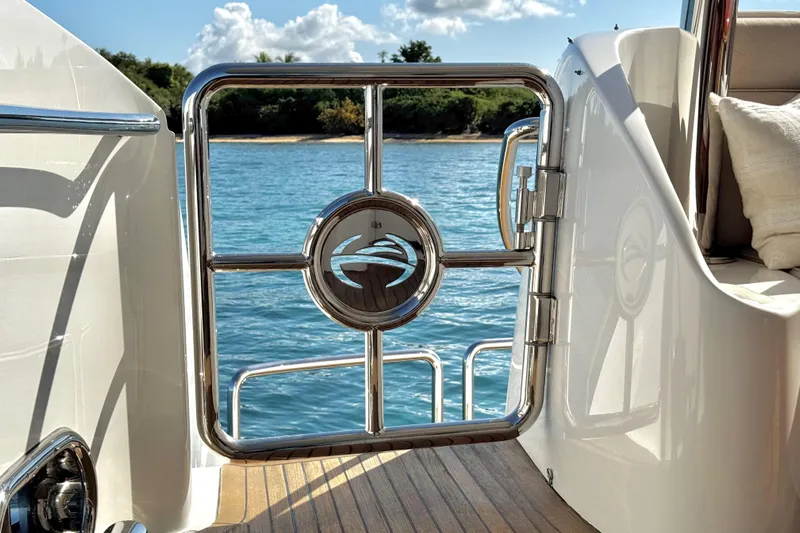 Tortuga Yacht Photos Pics Stainless steel gate on Horizon E88 yacht, overlooking serene blue water.