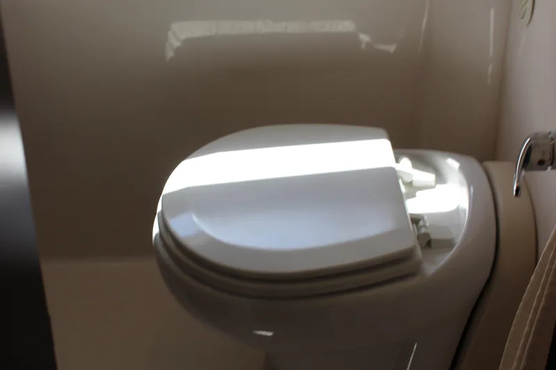 Yacht Photos Pics Toilet in 2014 Regal 32 Express boat bathroom, with sunlight highlighting the seat.