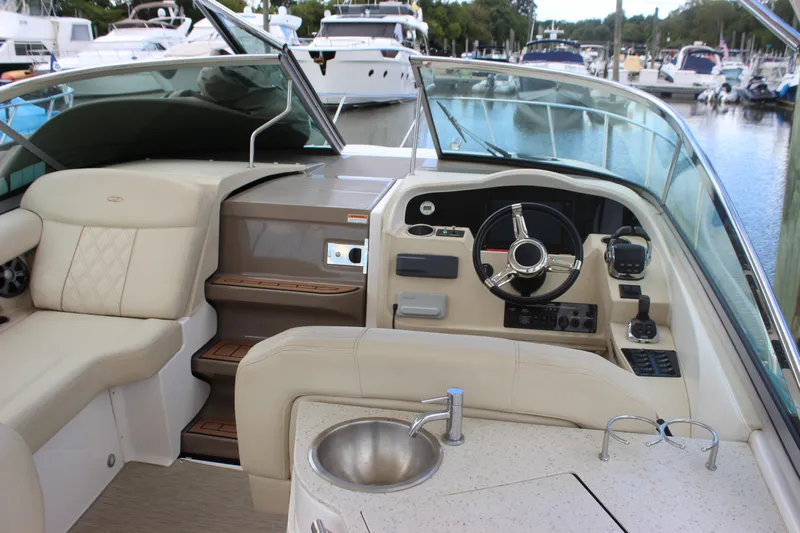  Yacht Photos Pics 2014 Regal 32 Express boat interior with steering wheel and seating at marina.