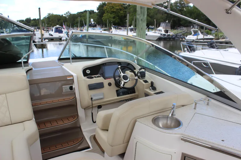  Yacht Photos Pics Interior of 2014 Regal 32 Express boat, featuring helm and seating area at marina.