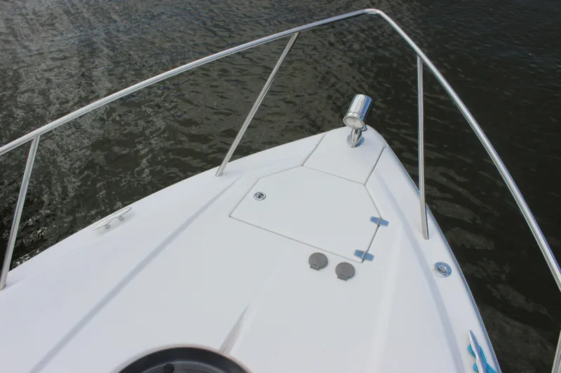 Yacht Photos Pics Bow of 2014 Regal 32 Express boat with stainless steel railings on water.