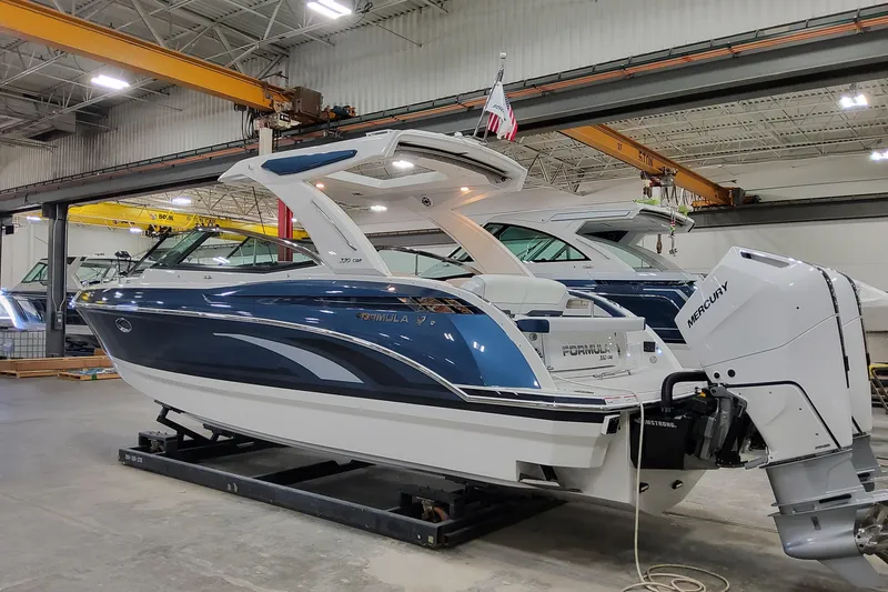 Yacht Photos Pics 2026 Formula 330 Crossover Bowrider OB in a showroom, featuring sleek design and Mercury outboard engine.