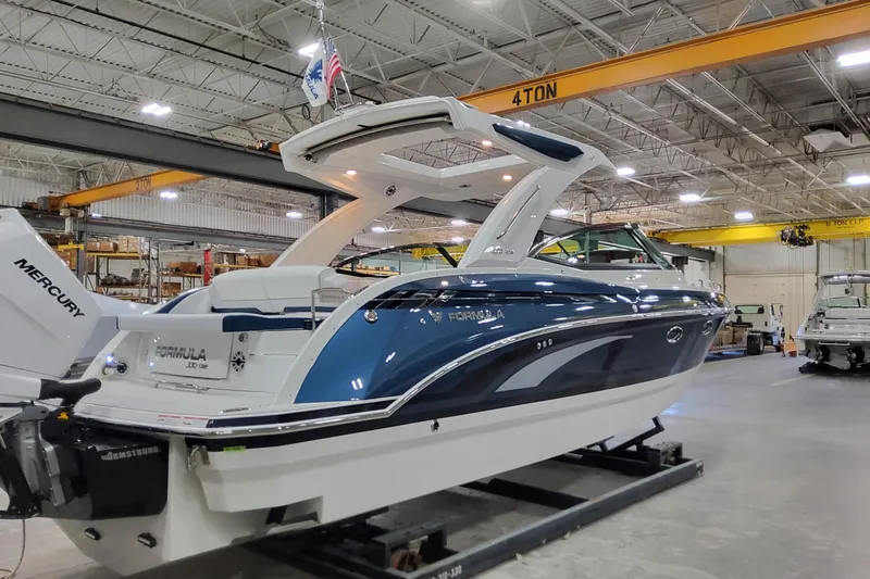  Yacht Photos Pics 2026 Formula 330 Crossover Bowrider OB in a warehouse, featuring sleek design and Mercury engine.