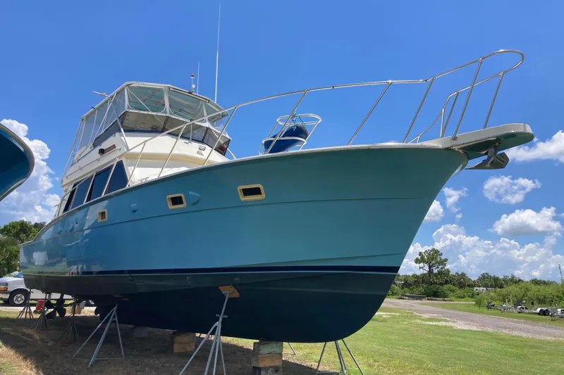 Golden Olive Yacht Photos Pics 1985 Hatteras Sportfish boat on stands under a clear blue sky.