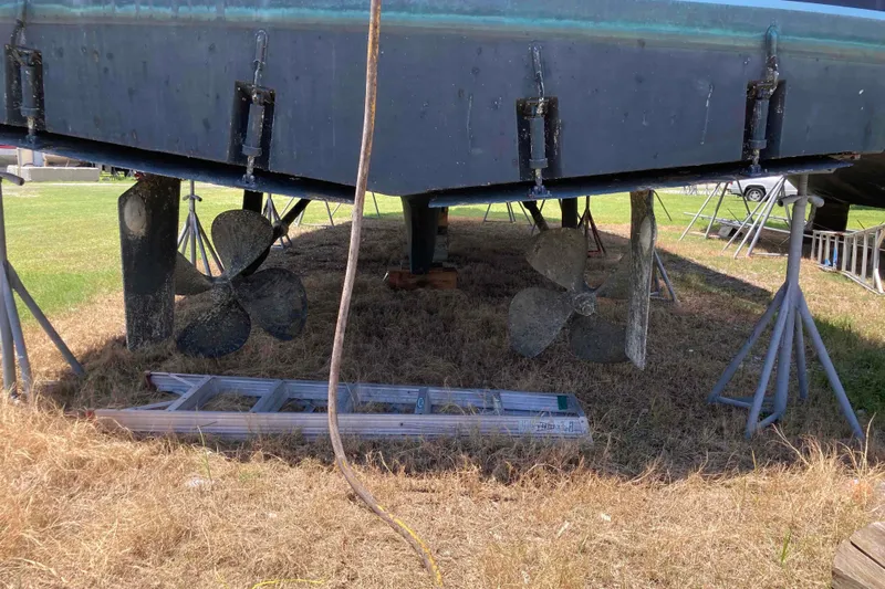 Golden Olive Yacht Photos Pics 1985 Hatteras Sportfish boat on stands, showing propellers and rudders.