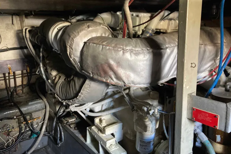 Golden Olive Yacht Photos Pics Engine room of a 1985 Hatteras Sportfish boat, showcasing complex machinery and wiring.