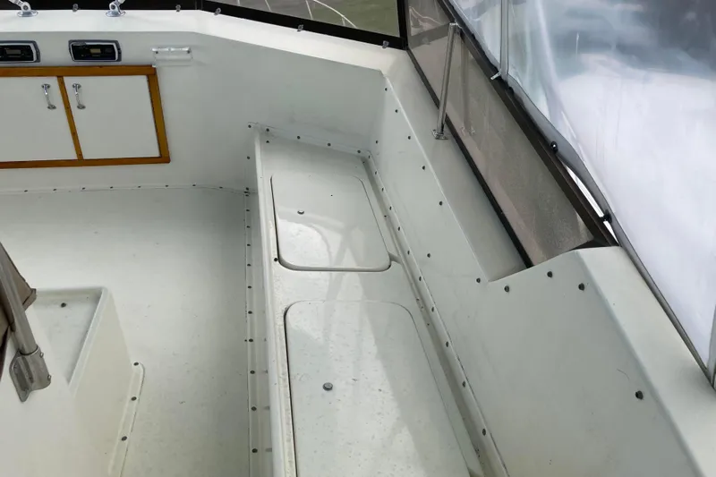 Golden Olive Yacht Photos Pics 1985 Hatteras Sportfish boat interior with white seating and storage compartments.